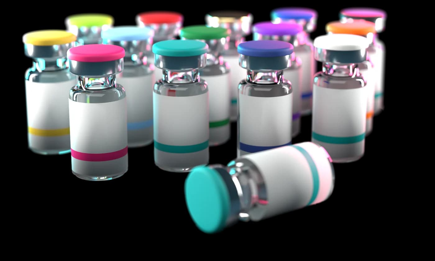 A group of research vials with colored caps and plain labels, one lying on its side in front.